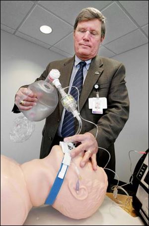 Dr. David Lindstrom, EMS medical director, demonstrates the ResQPOD device, which helps deliver the optimum amount of air and improves blood flow to the heart.
