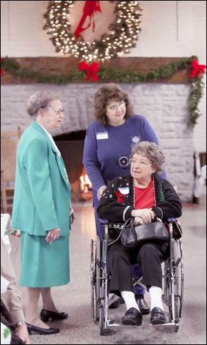 Alda Farber, left, talks with Virginia Gordon, another former Tiedtke employee who is assisted by her daughter, Sandie Ottney, rear, at the reunion of associates at Walbridge Park.
