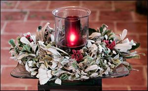 Candles may be displayed in a variety of ways to give homes a special touch. Among the possibilities: with seasonal greenery.
