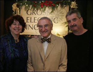 Linda Gross, left, and her brother, Joe Gross, right, with their father, Richard Gross, at the Gross Electric holiday party.