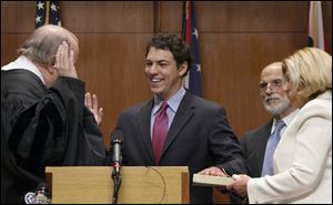 Ben Konop is sworn in as Lucas County's newest commissioner by Ohio 6th District Court of Appeals Judge William Skow as his parents, Alan and Barbara Konop, watch.
