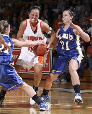 Bowling Green State University's Ali Mann splits the defense of Delaware's Kyle DeHaven, left, and Melissa Czorniewy.