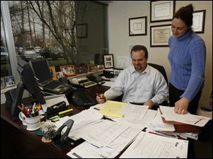 Jeff Brubaker and Jennifer Bryant work with client documents. The firm serves medium-to-large, privately owned companies as well as several publicly owned companies in the region. 
