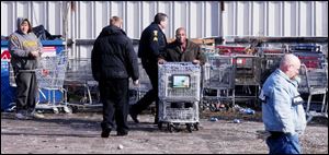Keith Williams, manager at the Kroger at Manhattan Plaza, takes away some of the carts found at Lagrange Metals.