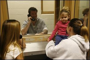Shane Szymkowiak, middle, is visited by his niece Chelsy Barker, 14, left, and his sister Shelly Skeels, right, with her child Emily, 3, all of Perrysburg, at the Wood County jail.