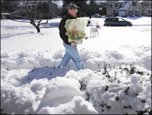 Bill Asendorf, of Joe Cooper Florist, carries an order of Valentine's Day flowers to a customer on Grand Valley Road in Maumee yesterday. Deliveries were stymied by the weather.