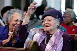 Dora Garner, left, applauds as her mom Lillian Russell-Jones is introduced at a special program at St. Paul Baptist Church.