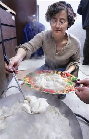 Helen Zhu ladles out tasty cooked dumplings, a traditional symbol of wealth.