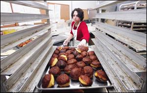 Laura Hayden prepares a tray of paczki at Bakery Unlimited, which supplies the Lagrange Village Council with the treats. Paczki, a confection of dough and filling, will be sold on Fat Tuesday.