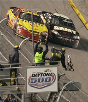 Kevin Harvick, left, and Mark Martin, both in Chevrolets, cross the Daytona 500 finish line almost in a dead heat yesterday.