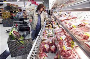 Tracey Doughten of Oregon shops in the meat department at Meijer in Oregon. Analysts say Meijer, Kroger, and other grocers are losing market share to Wal-Mart s grocery sales.
