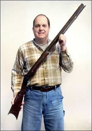 Bill Lorenzen holds the flintlock rifle used by his great grandfather, Washington Avery, who shot the last known wild bear in Wood County in 1858.
