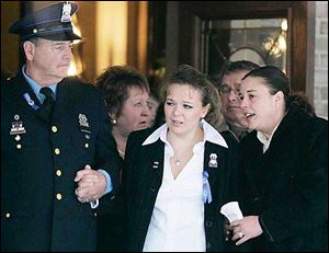 Danielle Dressel, widow of Detective Keith Dressel is escorted from the funeral home.