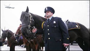 Mounted police Officer Greg Zattau holds the riderless horse, symbolizing the fallen hero, which was part of the funeral procession for Detective Keith Dressel.