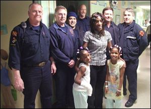 Aireana McClellan, at left front, mom Latisha Miller, and sister
Alayza McClellan celebrate their escape from the fi re with
Toledo fi refi ghters Lt. Joe Schwanzl, left, Randy Roslin, Tony
Salazar, Doug Haack, Jerry Saunders, and Brian Schoen.
