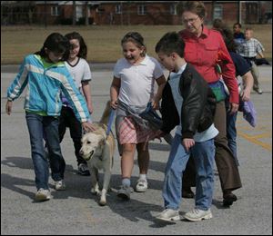 Bigelow Hill Intermediate School students Jenna Lewis, Katelyn Frost, Alexis Franks, and Steven Holtgreven walk Dixie back to school after recess. School counselor Nancy Baxter joins them.