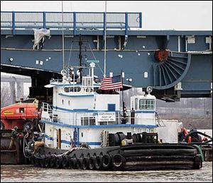 Workers unhook the tug John Francis as it turns a drawbridge section before pushing it into position on the Martin Luther King, Jr., Bridge today.