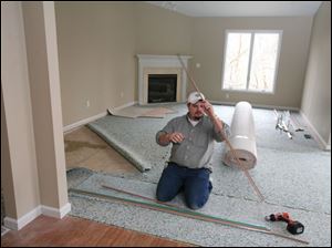 biz build25p  3_21_2007 photo by herral long  DeWayne monroe  with  Monroe carpeting works on one of the 10 new units   note the weather was bad and there was no work going on outside  i did run into the builder Dave Filas   419 360 8815  -- and they were working inside one of the homes  putting down carpet.  Need stand-alone art for Sunday business section. Get various  shots of workers-- hopefully -- building houses at the new subdivison,  the Village at Laurel Hills ______________