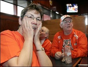 Janice Veitch, left, her father, Dale Plumb, center, and her brother, Dick Plumb, watch the game in Bowling Green.