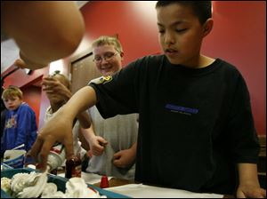 Dalton Hicks, left, watches Brandon Lee put the finishing touches on the sundae with a puff of whipped cream.
