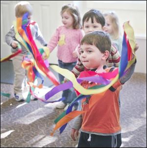 Alex Peres, 3, swings his rythym ribbons to the beat of the music during the music class.