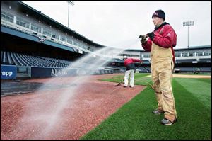 Jake Tyler, foreground, and Paul Masuga prepare the playing surface at Fifth Third Field, including a new layer of warning track, for tonight s home opener when the Mud Hens entertain the Durham Bulls, starting at 5:30.  It s in really good shape considering the weather we ve had,  Tyler said.