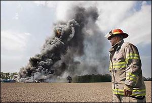 Steven Lewis, a firefighter with the Toledo Fire Department, examines the blaze at Reliance Propane in Bedford Township, Michigan. 