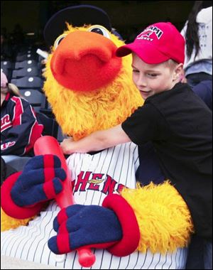 Nick Gibb, 11, gives Muddy a hug in the stands of Fifth Third Field as the Toledo Mud Hens host the Louisville Bats. Nick and some of his classmates from St. Joan of Arc School attended yesterday s game, which the Bats won 5-4. 