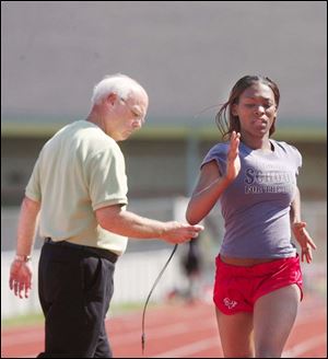 Rogers senior Chanelle Caldwell is timed in practice by Rams coach Joe Souliere. Caldwell set a City League meet record in the 800 with a time of 2:16.97. She is the defending district champion in the event.