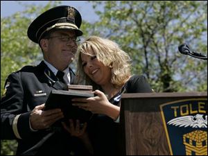 Police Chief Mike Navarre embraces Danielle Dressel at a ceremony during which the late detective s badge was retired.
