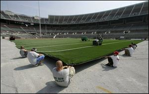FieldTurf specialists install the new synthetic surface for Ohio Stadium, which has used natural grass since 1990.