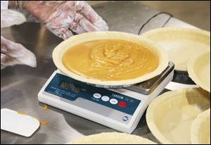 A pie is weighed to check for the correct amount of filling.
