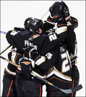 Ducks center Rob Niedermayer, back right, is mobbed by teammates after scoring a goal in the first period last night as Anaheim beat Detroit to advance to the Stanley Cup finals.