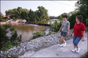 Mary Lynn Schumm, left, and Beth Nelson walk by Riverside Park's Waterfalls Area in Findlay, near the new scenic byway.