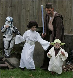 Reese, 4, Reagan, 8, Corinne, 2, and their dad Mike Shull, in their Star Wars costumes in his Scottwood home backyard.
