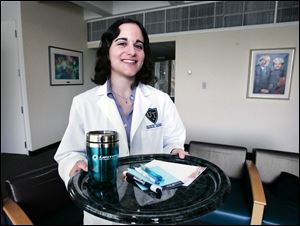 Medical student Mary LaSalvia shows an array of items handed out by pharmaceutical companies.
The University of Toledo and other
institutions that train physicians are taking steps to limit such gifts.
