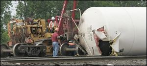 Workers clean up derailed cars at CSX's Stanley Yard in Lake Township. About 150 gallons of material spilled, but no one was injured in the incident that occurred about 1:40 a.m. yesterday.