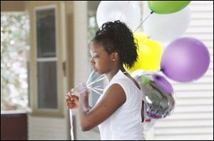 Britnay Slay, 16, puts up the party balloons. As a child, Britnay had to distinguish two grandmothers. Allissa has three.