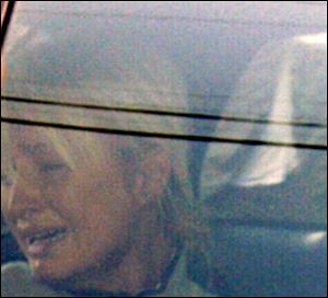 Paris Hilton, crying in a sheriff's patrol car, was returned to court today, where a judge ordered her back to jail.