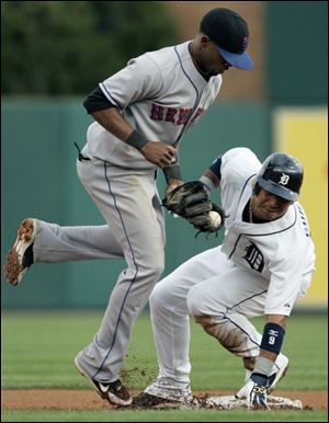 Detroit's Carlos Guillen steals second base as New York Mets shortstop Jose Reyes tries to keep the ball in his glove.