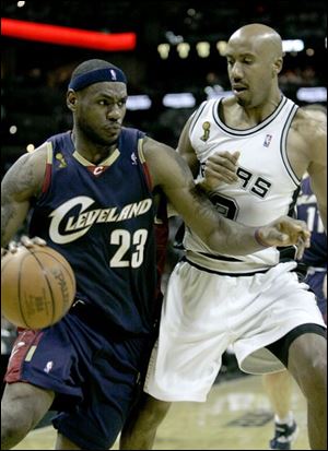 Cleveland's LeBron James gets a step ahead of San Antonio defender Bruce Bowen in Game 1. James scored 14 points and had only four assists, far below expectations of Cavaliers fans.