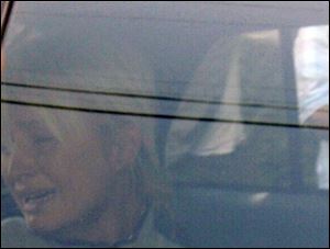 Paris Hilton weeps in a police car as she is taken from her Hollywood Hills home to Los Angeles County Superior Court.
