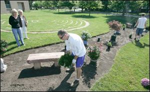 Jeff Miller plants flowers, with guidance from Malinda Meinhert, left, and Gloria Moorehead, next to a labyrinth at Angel s Landing Spiritual Center, 3220 Meadowbrook Court, Toledo. The labyrinth and Gloria s Garden, named in honor of Ms. Moorhead, the church founder, will be dedicated in a service at 11:30 a.m. tomorrow.