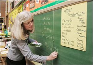 Teacher Marcia Little writes names of micro greens.