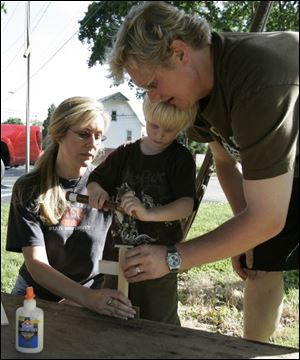 Robbie Clark, 4, gets some help from his mother, Amy, and his father, Kerry, at the festival's Make-It and Take-It tent.
