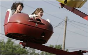 Lauren Altenburger, 12, left, and Rachel Langenderfer, 12, both of Maumee, take a ride at the Whitehouse Cherry Festival. 
