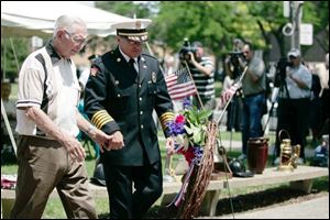 John Timmers, 91, whose firefighter father was killed while on a run in 1916, is escorted to the wreath -placing ceremony by Acting Chief Michael Wolever during the memorial service at Chub DeWolfe Park. 