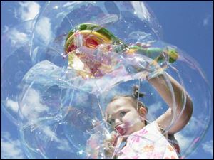 Four-year-old Toledoan Jordyn D'Clute, above, demonstrates the art of blowing soap bubbles, among children's activities at Saturday's Bike-a-Thon and Family Fun Festival in Oregon.