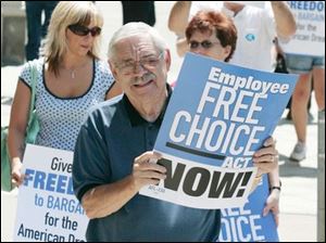 BIZ worker14p 06/13/07 The Blade/Dave Zapotosky Location: Toledo, Ohio Caption: Ron Coughenour, legislative director of the Toledo Area AFL-CIO, center, demonstrates with other workers and activists in favor of the Employee Free Choice Act outside of the Ohio Building Wednesday afternoon.  The group also presented 1,000 postcards to a representative of U.S. Senator George Voinovich who has an office in the building. Summary: Toledo workers and community activist groups will assemble outside the Ohio Building and deliver 1,000 postcards to representives of Senator George Voinovich, who has an office in the building. They are urging support of the Employee Free Choice Act, which is currently pending in the U.S. Senate.