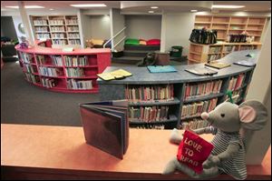 A stuffed animal waits for the influx of young readers, with the library's moto 